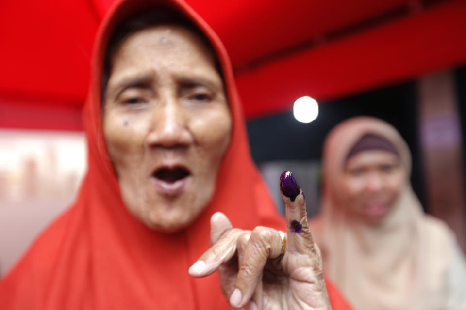 A woman shows her inked finger after casting her ballot at a polling station during the election in Jakarta, Indonesia, Wednesday, April 17, 2019. Voting is underway across Indonesia in presidential and legislative elections Wednesday after a campaign that pitted the moderate incumbent against an ultranationalist former general. (AP Photo/Tatan Syuflana)