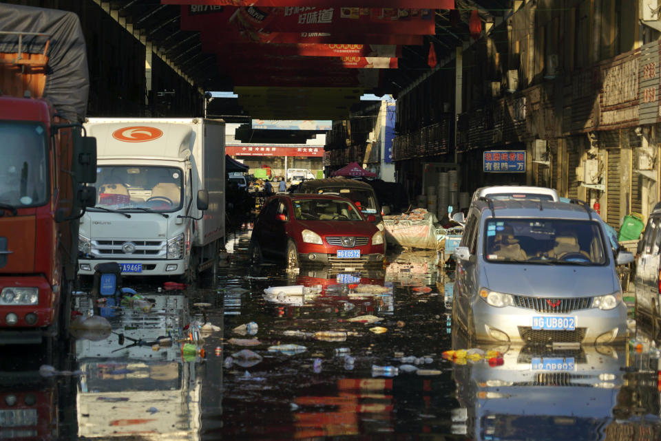 Vehicles sit in floodwaters at the Yubei Agricultural and Aquatic Products World in Xinxiang in central China's Henan Province, Monday, July 26, 2021. Record rain in Xinxiang last week left the produce and seafood market soaked in water. Dozens of people died in the floods that immersed large swaths of central China's Henan province in water. (AP Photo/Dake Kang)