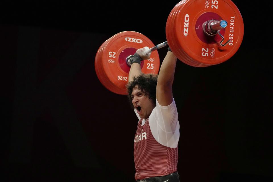 Fares Ibrahim Elbach of Qatar ccompetes in the men's 81kg weightlifting event, at the 2020 Summer Olympics, Saturday, July 31, 2021, in Tokyo, Japan. (AP Photo/Luca Bruno)