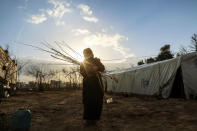 <p>An internally displaced Syrian woman, who fled from East Ghouta region as Assad Regime violates the ceasefire on ongoing civil war, carries a bundle of tree branch at a makeshift camp, relatively safer than their home neighborhoods in Damascus, Syria on Jan. 10, 2017. (Photo:Tarik al Masri/Anadolu Agency/Getty Images) </p>