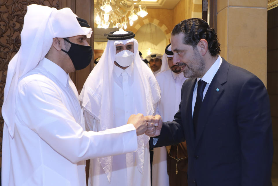 In this photo released by Lebanon's official government photographer Dalati Nohra, Lebanese Prime Minister-Designate Saad Hariri, right, greets with a fist bump Qatar's Deputy Prime Minister and Foreign Minister Sheikh Mohammed bin Abdulrahman bin Jassim Al-Thani, as he welcomes him at his house, in Beirut, Lebanon, Tuesday, July 6, 2021. Qatar's Foreign Minster is in Beirut for one day visit to meet with Lebanese officials and the Lebanese Army Commander Gen. Joseph Aoun. (Lebanon Government/Dalati Nohra via AP)