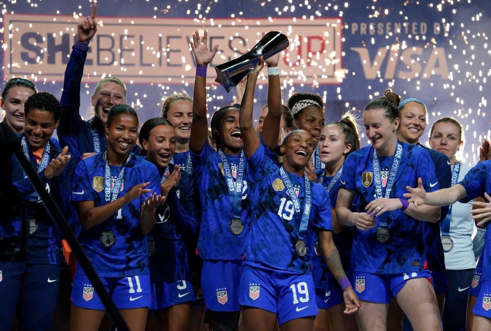 Crystal Dunn #19 of the United States hoists the trophy with her teammates after defeating Brazil in the 2023 SheBelieves Cup match Feb. 22, 2023, at Toyota Stadium in Frisco, Texas.