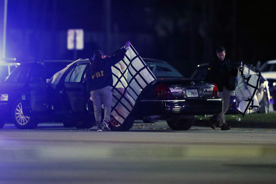 Authorities investigate the scene of a shooting Thursday, Dec. 5, 2019, in Miramar, Fla. Four people, including a UPS driver, were killed Thursday after robbers stole the driver's truck and led police on a chase that ended in gunfire at a busy Florida intersection during rush hour, the FBI said. (AP Photo/Brynn Anderson)