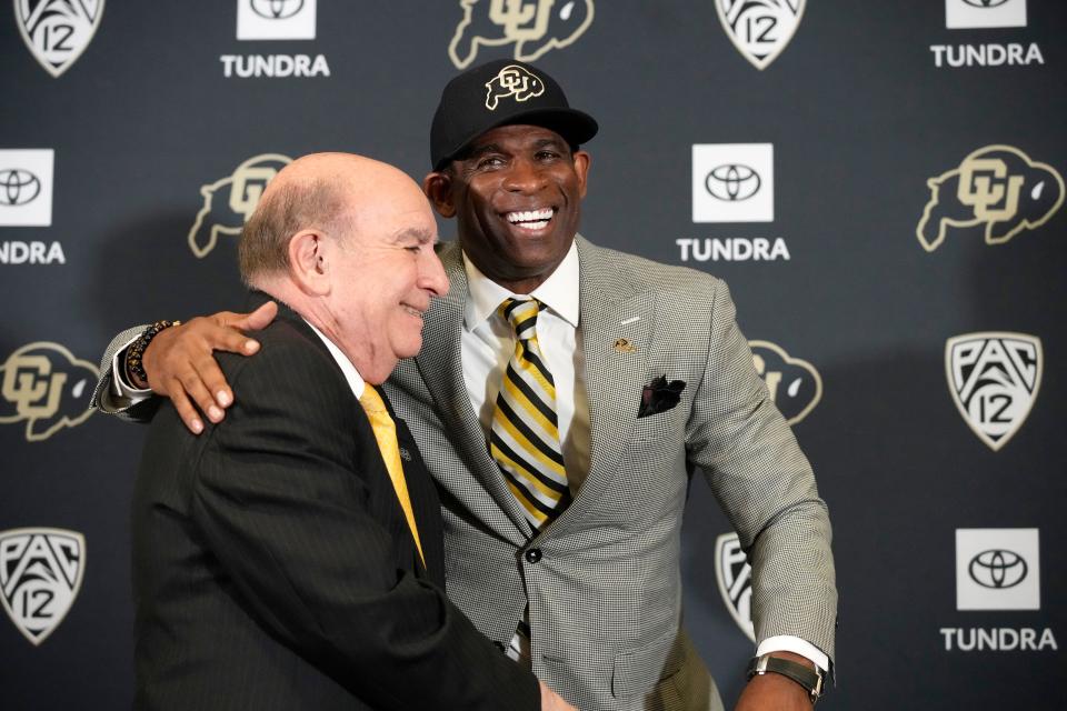 Deion Sanders, right, hugs Phil DiStefano, chancellor of the University of Colorado Boulder, after Sanders was introduced as the new head football coach Dec. 4, 2022.