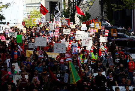 Demonstrators walk down Madison Street during the March for Immigrant and Workers Rights on May Day in Seattle, Washington, U.S. May 1, 2018. REUTERS/Lindsey Wasson
