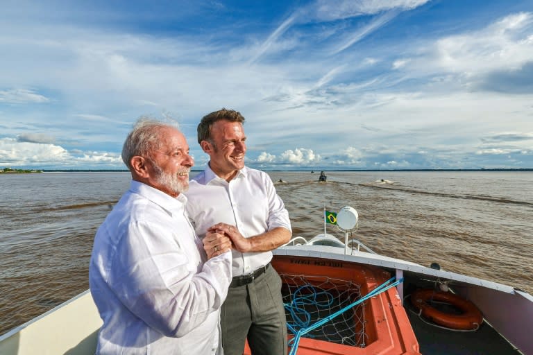 Photo publiée par la présidence brésilienne montrant le président brésilien Luiz Inacio Lula da Silva (G) et le président français Emmanuel Macron se tenant la main alors qu'ils naviguent dans la baie de Guajara au large de Belem, au Brésil, le 26 mars 2024 (Ricardo STUCKERT)