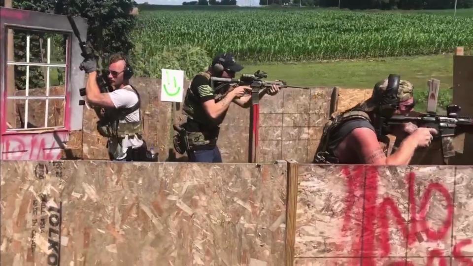 The photo shows defendant Kaleb Franks (at far left) with a rifle equipped with a suppressor, also known as a silencer, used to muffle both the sound and the flash of rifle fire.