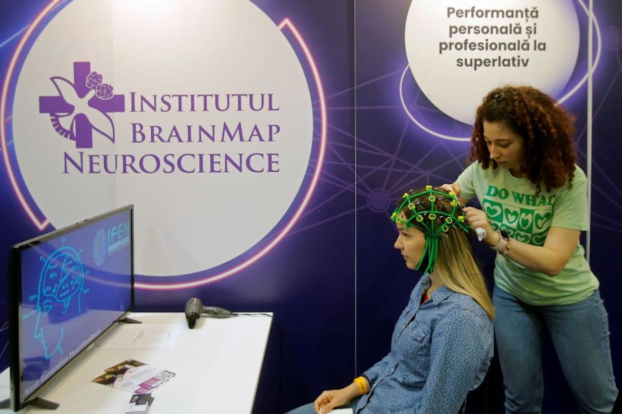 A woman tries out neurotechnology equipment during Tech Week in Bucharest, Romania, in May 2023. <a href="https://www.gettyimages.com/detail/news-photo/woman-tries-neuro-technology-equipment-at-the-tech-expo-news-photo/1258279319?adppopup=true" rel="nofollow noopener" target="_blank" data-ylk="slk:Cristian Cristel/Xinhua via Getty Images;elm:context_link;itc:0;sec:content-canvas" class="link ">Cristian Cristel/Xinhua via Getty Images</a>