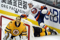 New York Islanders center Jean-Gabriel Pageau (44) trips over Boston Bruins defenseman Charlie McAvoy (73) as Bruins goaltender Tuukka Rask (40) guards the net in the second period of an NHL hockey game, Thursday, April 15, 2021, in Boston. (AP Photo/Elise Amendola)