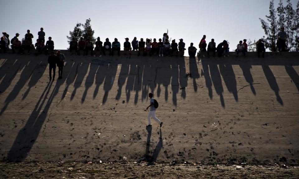 Migrants near the border crossing between Tijuana and California.