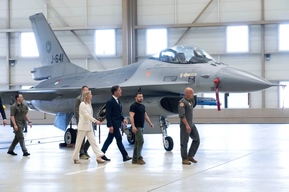 Ukrainian President Volodymyr Zelenskyy, second right, and Dutch caretaker Prime Minister Mark Rutte, center, look at F-16 fighter jets in Eindhoven, Netherlands, on Aug. 20, 2023.