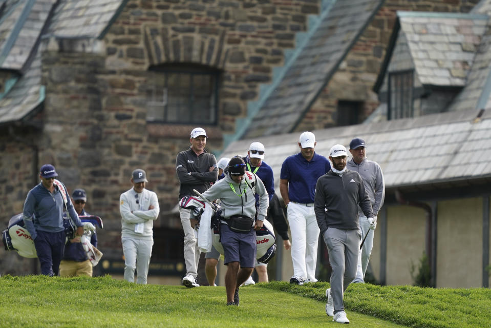 Dustin Johnson, second from right, walks down the 10th hole fairway during practice for the U.S. Open Championship golf tournament at Winged Foot Golf Club, Tuesday, Sept. 15, 2020, in Mamaroneck, N.Y. (AP Photo/John Minchillo)