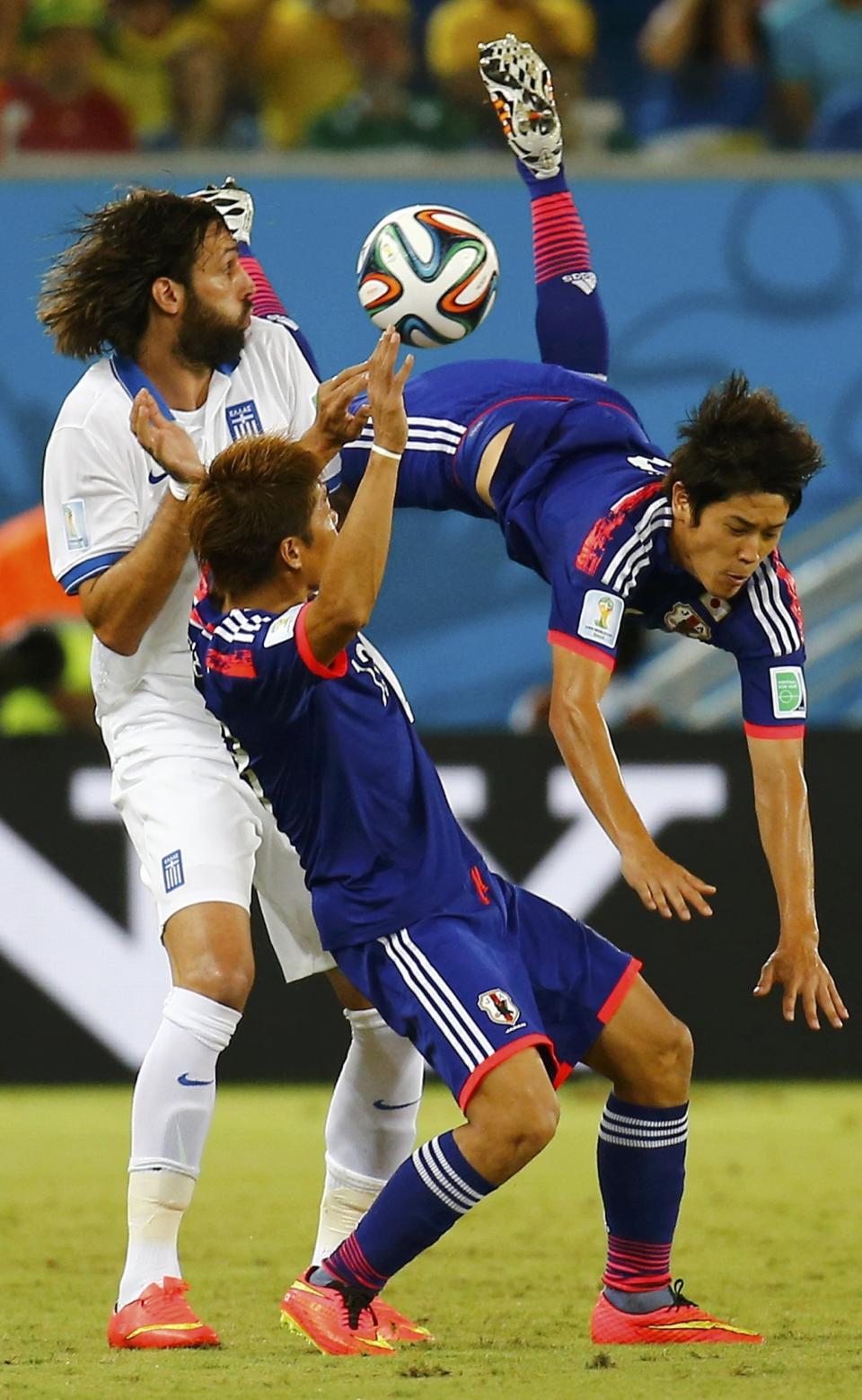 Japan's Atsuto Uchida (R) is fouled by Greece's Giorgios Samaras (L) as Japan's Yoshito Okubo reacts during their 2014 World Cup Group C soccer match at the Dunas arena in Natal June 19, 2014. REUTERS/Kai Pfaffenbach (BRAZIL - Tags: SOCCER SPORT WORLD CUP)