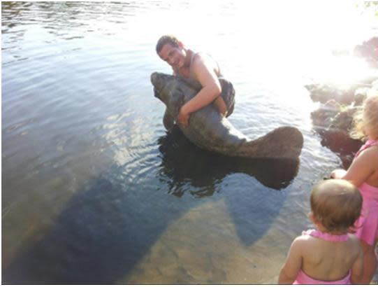 A man was arrested after posting photos on Facebook that showed him picking up a manatee.