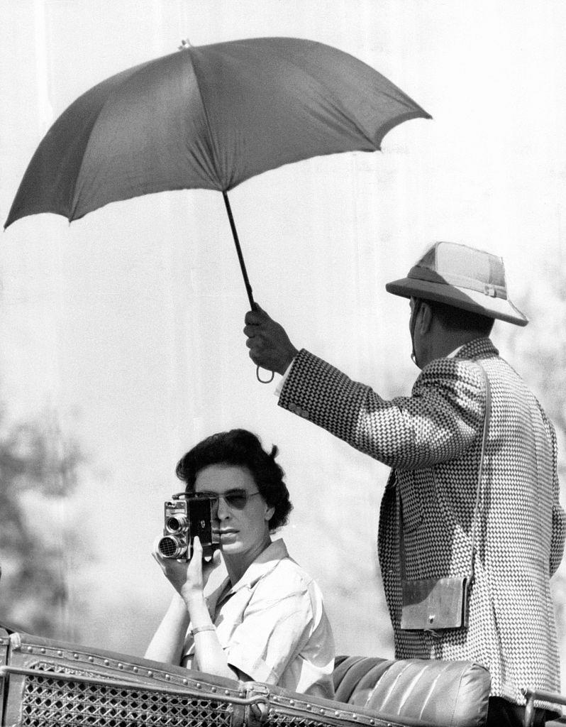 <p>A helpful man allows the Queen to photograph from the shade.<br></p>