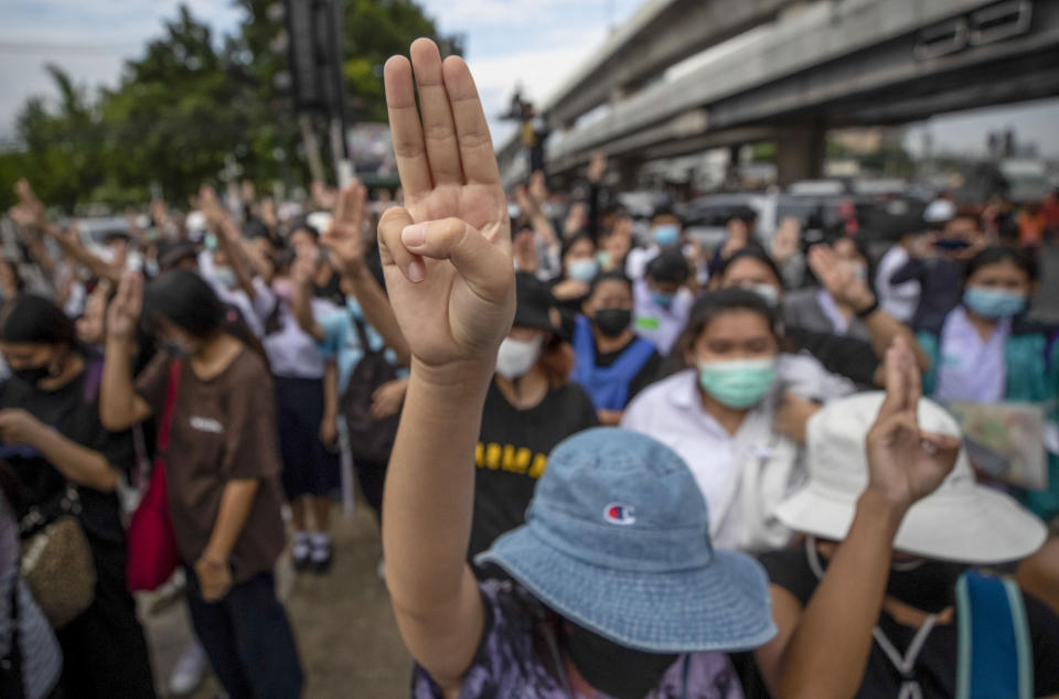 Pro-democracy activists flash three-fingered salute during a demonstration at Kaset intersection, suburbs of Bangkok, Thailand, Monday, Oct. 19, 2020. Thailand's embattled Prime Minister Prayuth Chan-ocha said Monday that there were no plans to extend a state of emergency outside the capital, even as student-led protests calling for him to leave office spread around the country. (AP Photo/Sakchai Lalit)