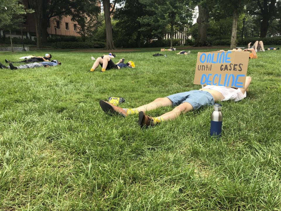 A protester holds a sign opposing in-person classes Monday, August 17, 2020, at a "die-in" at Georgia Tech in Atlanta. More of the state's public universities are opening for the fall term, trying to balance concern about COVID-19 infections against a mandate for on-campus classes citing financial needs and student desires (AP Photo/Jeff Amy)
