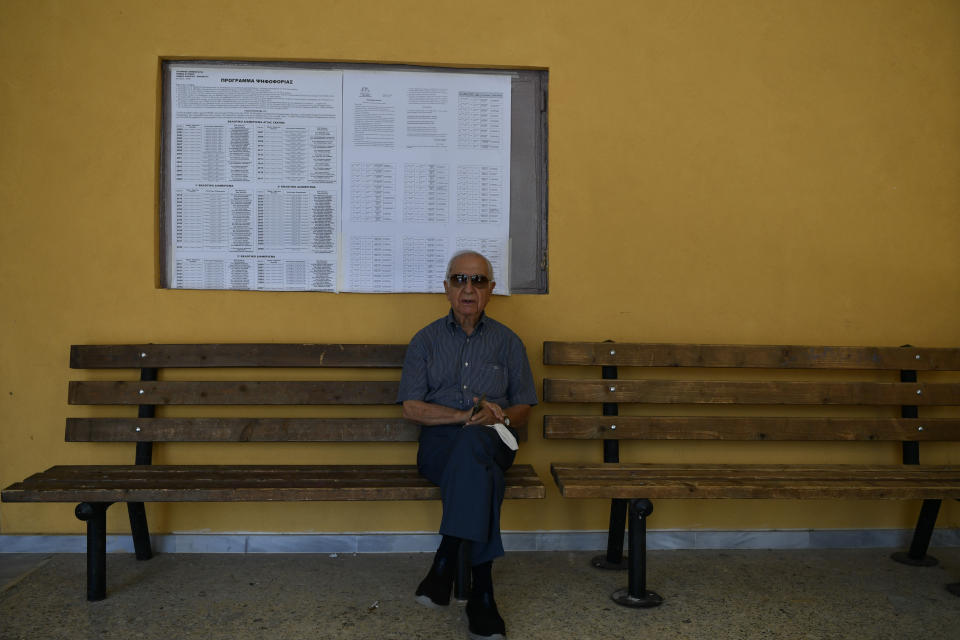 A man sits on a bench outside a voting center during municipal elections, in Cholargos suburb, Athens, Greece, Sunday, Oct. 15, 2023. The country's two largest cities, and 6 of its 13 regions, are at play in Sunday's runoffs, with low turnout expected again. (AP Photo/Michael Varaklas)