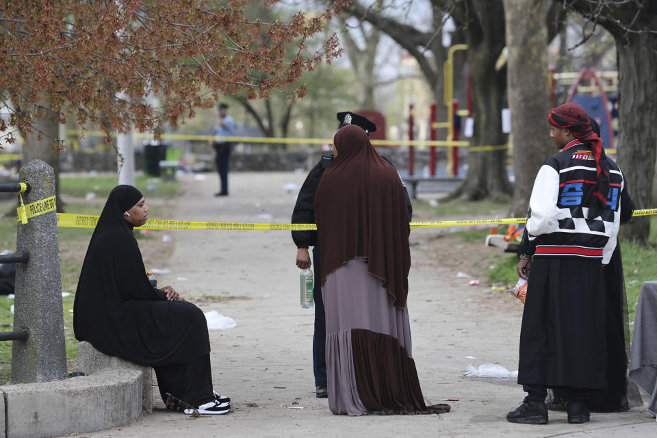 Varias personas hablan con la policía luego de un tiroteo durante un evento de la festividad musulmana de fin del ayuno, el miércoles 10 de abril de 2024, en Filadelfia. (Monica Herndon/The Philadelphia Inquirer vía AP)