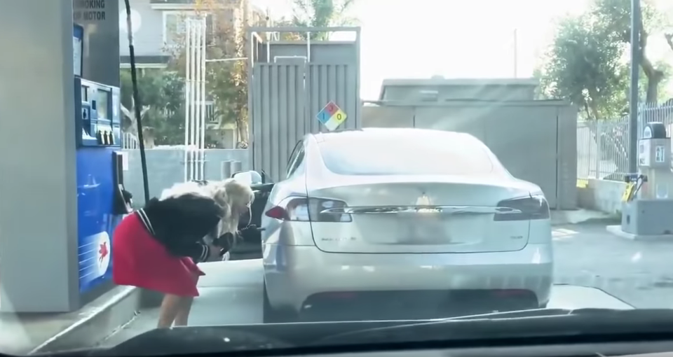 <p>Footage shows the driver looking puzzled as she searches for the car’s filler cap</p>