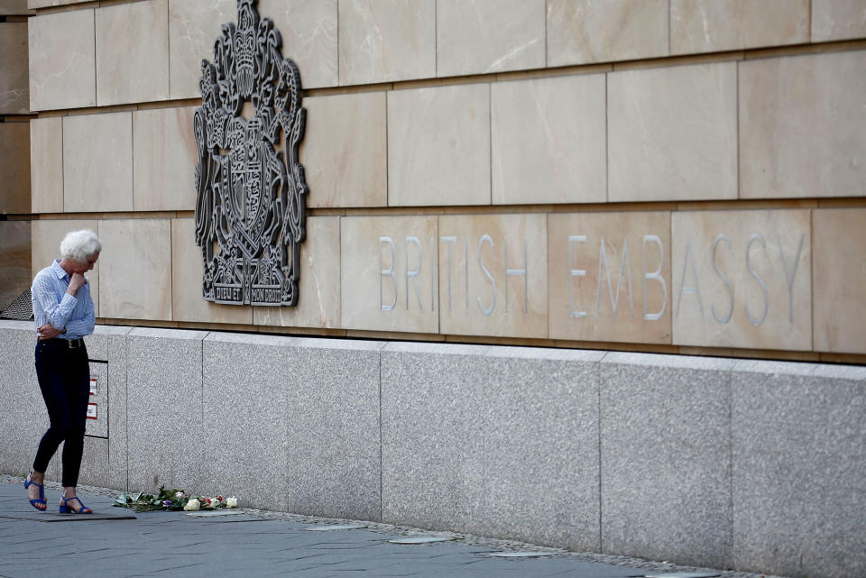 <p>A woman walks past flowers, as a tribute for victims of Monday’s suicide bombing at Manchester Arena in the English city of Manchester, in front of the British embassy in Berlin, Germany on May 23, 2017. (Fabrizio Bensch/Reuters) </p>