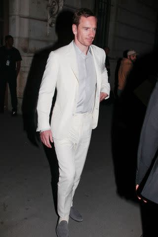 <p>Spread Pictures / MEGA</p> Michael Fassbender photographed in a white suit at Louis Vuitton event.