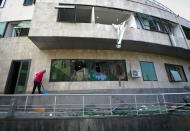 A man removes debris at a hospital damaged by shelling by Azerbaijan's artillery in Stepanakert, the separatist region of Nagorno-Karabakh, Wednesday, Oct. 28, 2020. Nagorno-Karabakh officials said Azerbaijani forces hit Stepanakert, the region's capital, and the nearby town of Shushi with the Smerch long-range multiple rocket systems, killing one civilian and wounding two more. (AP Photo)
