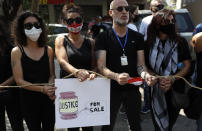 Lebanese anti-government activists protest outside a Lebanese court, as they demanding the improving judicial independence, in Beirut, Lebanon, Wednesday, June 17, 2020. A year after anti-government protests roiled Lebanon, dozens of protesters are being tried before military courts that human rights lawyers say grossly violate due process and fail to investigate allegations of torture and abuse. (AP Photo/Hussein Malla)