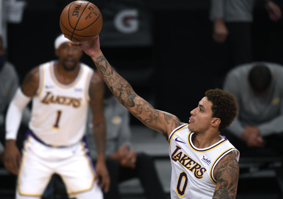 LOS ANGELES, CALIFORNIA - DECEMBER 13: Kyle Kuzma #0 of the Los Angeles Lakers scores on a layup in front of Kentavious Caldwell-Pope #1 during a preseason game against the LA Clippers at Staples Center on December 13, 2020 in Los Angeles, California. (Photo by Harry How/Getty Images)