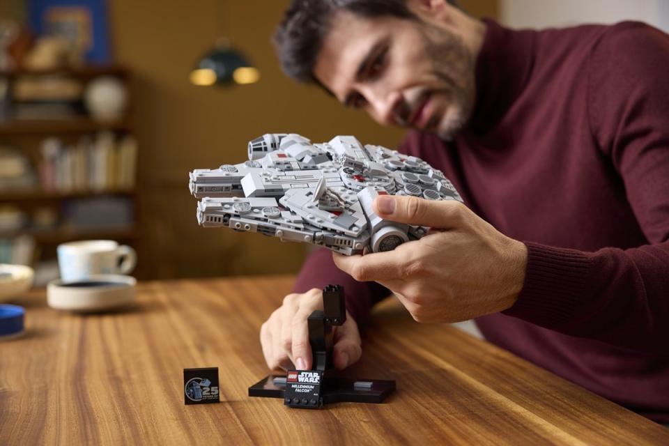 Builder plays with his completed LEGO Millennium Falcon.