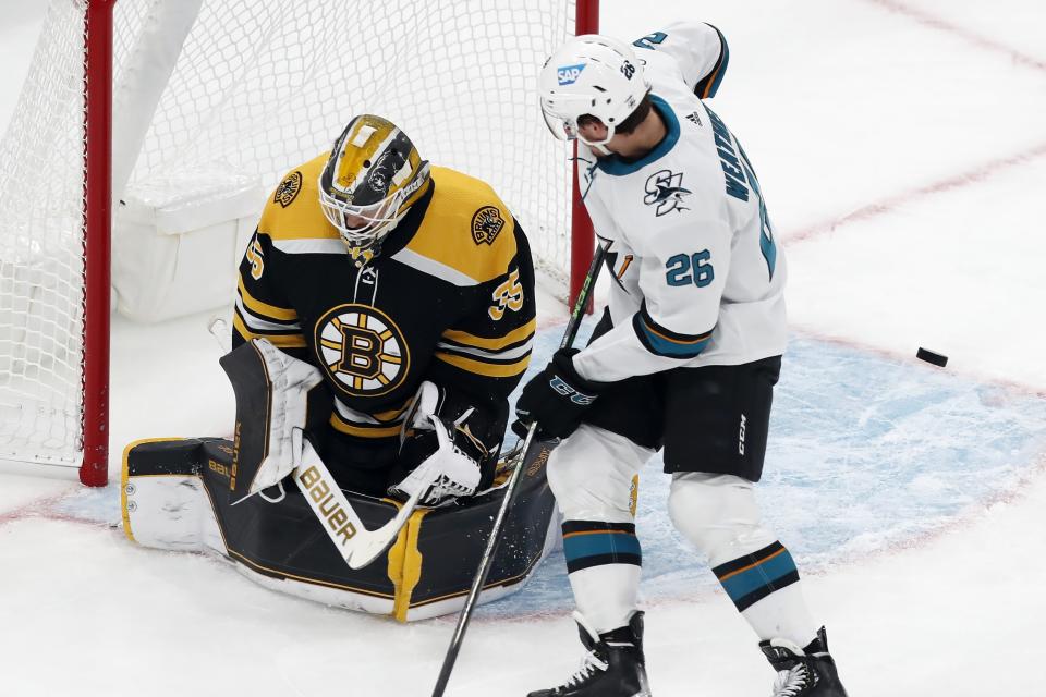 Boston Bruins' Linus Ullmark (35) deflects a shot in front of San Jose Sharks' Jasper Weatherby (26) during the first period of an NHL hockey game, Sunday, Oct. 24, 2021, in Boston. (AP Photo/Michael Dwyer)