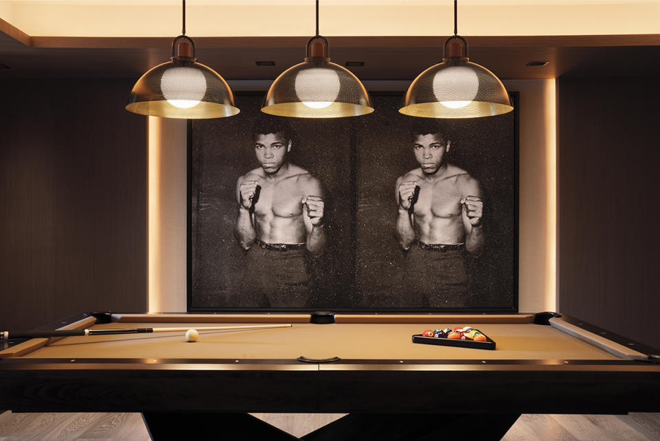 Russell Young’s Ali Diptych (2021) squares off against the pool table in the games room. 