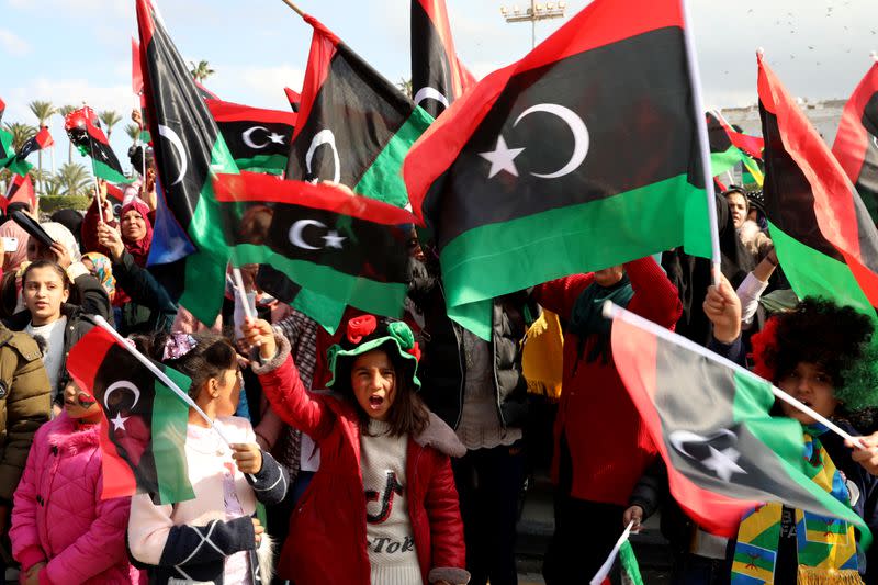 People wave Libyan flags as they gather during celebrations commemorating the 9th anniversary of the revolution at Martyrs' Square in Tripoli