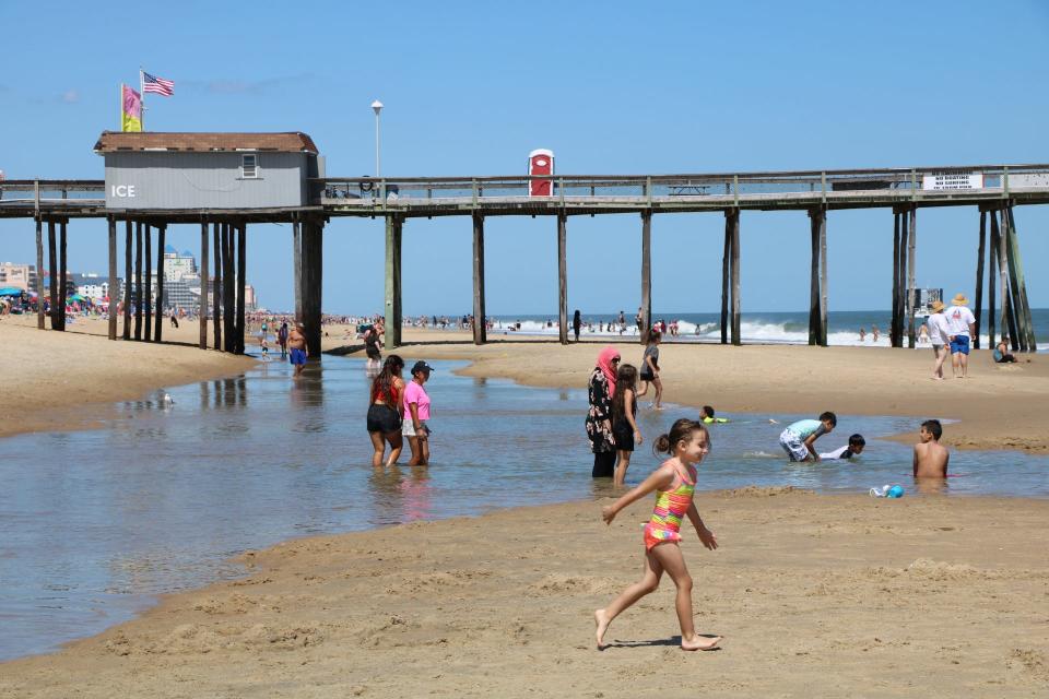 Visitors play in tide pools on the beach at Ocean City Thursday, Aug. 19, 2019. Tide pools form along the beachfront as rough winds increase the distance waves travel up the beach.