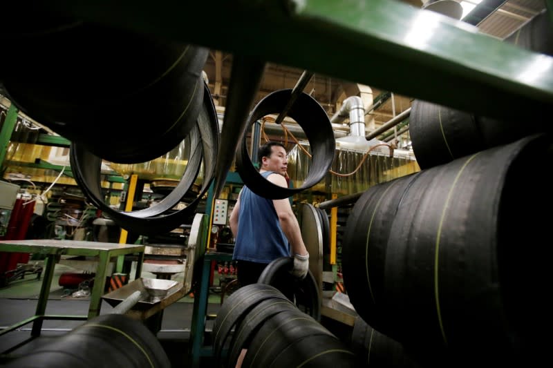 FILE PHOTO: An employee works on the production line of a tyre factory under Tianjin Wanda Tyre Group in Xingtai