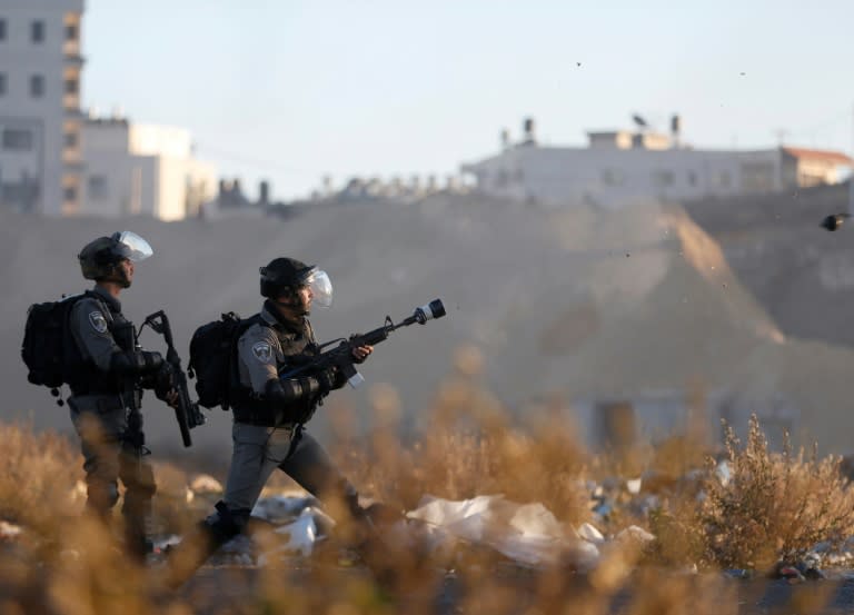 Israeli troops take position during clashes with Palestinian protesters near an Israeli checkpoint in the West Bank city of Ramallah on December 8, 2017