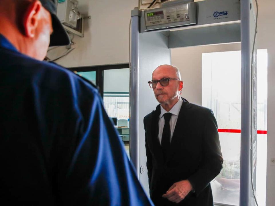 Canadian-born film director Paul Haggis enters through security at the court building in Brindisi, Italy, on Wednesday. He is facing charges of sexual assault and grievous bodily harm. (Salvatore Laporta/The Associated Press - image credit)