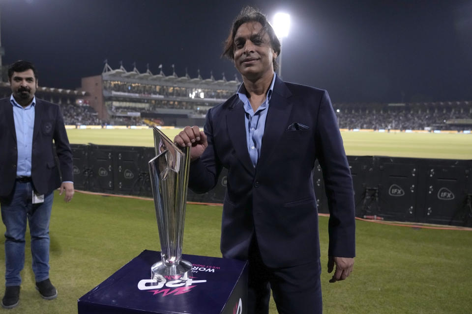 Pakistan's former cricketer Shoaib Akhtar poses for photo with the trophy of upcoming International Cricket Council's T20 cricket World Cup, which display at Gaddafi stadium, in Lahore, Pakistan, Saturday, April 27, 2024. (AP Photo/K.M. Chaudary)