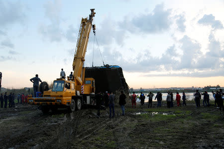 Members of the Iraqi Civil Defence rescue team lift a ferry which sank in the Tigris River with a crane in Mosul, Iraq March, 23, 2019. Picture taken March 23, 2019. REUTERS/Stringer