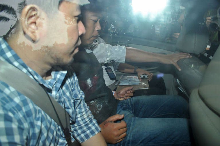 Iskandar Rahmat (in restraints) being escorted by police investigators as he leaves court on July 15, 2013 after being charged over the double murder. (Photo: Getty)