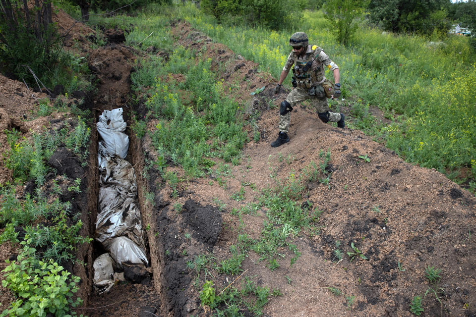 Un soldado ucraniano en una fosa común en las colinas desde donde se observa Lisichansk, Ucrania, el 16 de junio de 2022. (Tyler Hicks/The New York Times)
