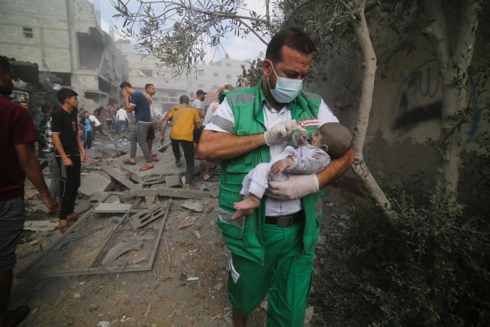 2023年10月22日，加薩走廊南部拉法（Rafah）遭空襲，醫護人員從廢墟下救出一名嬰兒。美聯社