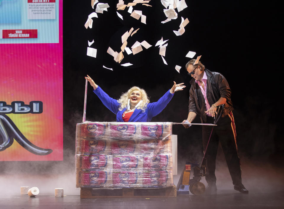 A singer at the Finnish National Opera performs the role of a greedy businessperson getting rich from the rush on toilet paper and face masks during a rehearsal for "Covid fan tutti," a satirical take on a famed opera by Wolfgang Amadeus Mozart but with an adapted contemporary story line that reflects the Nordic country's pandemic experiences, in Helsinki, on Thursday Aug. 20, 2020. The show follows the lives of ordinary Finish people, the news conferences by the government and pandemic experts with satirical undertones. (Stefan Bremer/Finnish National Opera via AP)