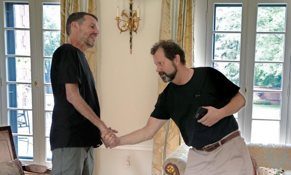 Bill Oesterle, left, works to lift his immobilized right arm as he shakes hands with neighbors at the end of a meeting Wednesday, June 8, 2022. Oesterle has ALS, or amyotrophic lateral sclerosis, an incurable disease that affects parts of the nervous system, affecting muscle movement. It is also called Lou Gehrig's disease.