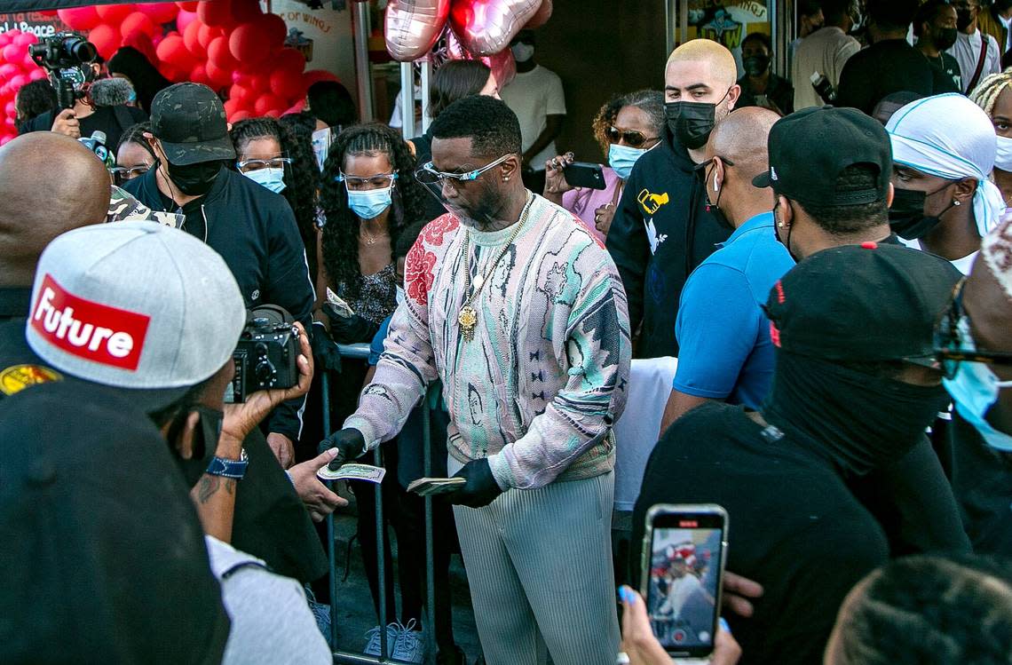 Rapper Sean “Diddy” Combs hands out $50 bills, gift cards and essentials during an event outside of the House of Wings restaurant to benefit and help Overtown residents in Miami. His Sean Combs Foundation joined with other groups to help the community in December 2020.