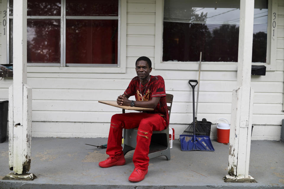 Joshua K. Love sits on his front porch in his "thinking chair," a classroom desk and chair he recently salvaged from a dumpster, in Greenwood, Miss., Saturday, June 8, 2019. “I guess there’s a child inside of me that still wants to sit there and learn,” he says. (AP Photo/Wong Maye-E)
