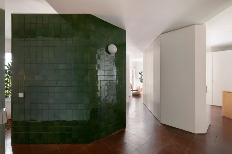 Green tiled wall in hallway.