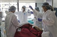 The team of Dr. Kedar Toraskar, head of critical care, make preparations to operate on a COVID-19 patient at the Mumbai Central Wockhardt Hospital in Mumbai, India, June 5, 2021. The recent coronavirus surge in India affected young people on a scale his team of critical care doctors hadn’t previously seen. (AP Photo/Rajanish Kakade)