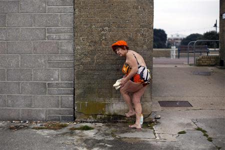 Hannemarie Mundell, 84, showers after a swim in the sea at the seafront in Portsmouth November 29, 2013. The British shipbuilding industry has been through a turbulent time after defence contractor BAE Systems announced in November that it planned to lay off 1,775 ship workers across the UK. REUTERS/Stefan Wermuth