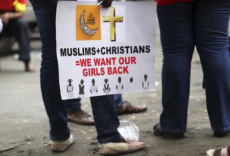 A protester holds a placard calling for the release of secondary school girls abducted in the remote village of Chibok, before a protest along a road in Lagos in this May 14, 2014 file photo. REUTERS/Akintunde Akinleye/Files